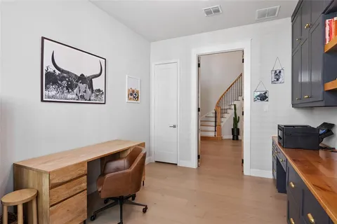 a hallway with a computer on a desk and cabinets