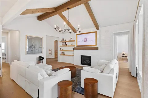 a living room with furniture a fireplace and a large mirror