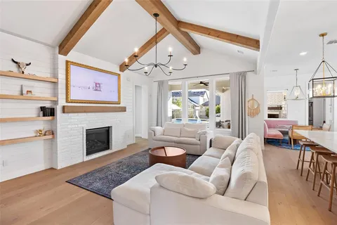 a living room with furniture a fireplace and a chandelier