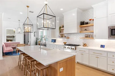 a kitchen with stainless steel appliances granite countertop a sink a stove and a wooden floors