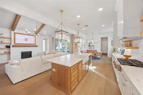 a large living room with stainless steel appliances kitchen island granite countertop furniture and a fireplace