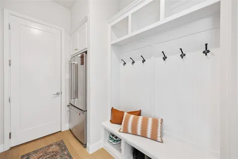 a view of hallway with wooden floor and bathroom