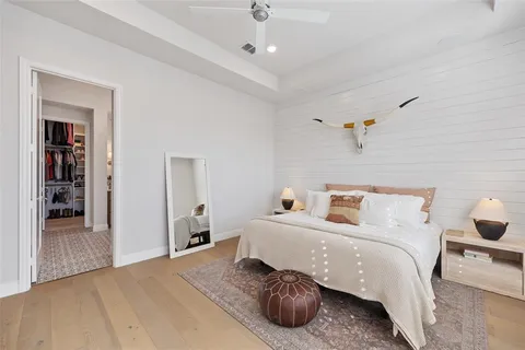 a bedroom with a bed and with a large mirror