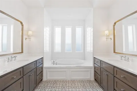 a bathroom with a tub sink shower and a mirror