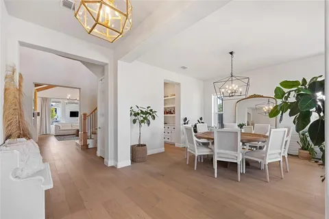 a dining room with furniture potted plants and wooden floor