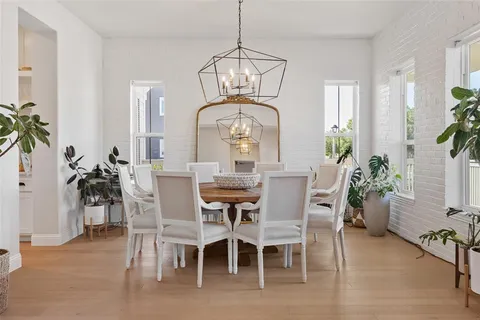 a dining room with furniture potted plants and wooden floor