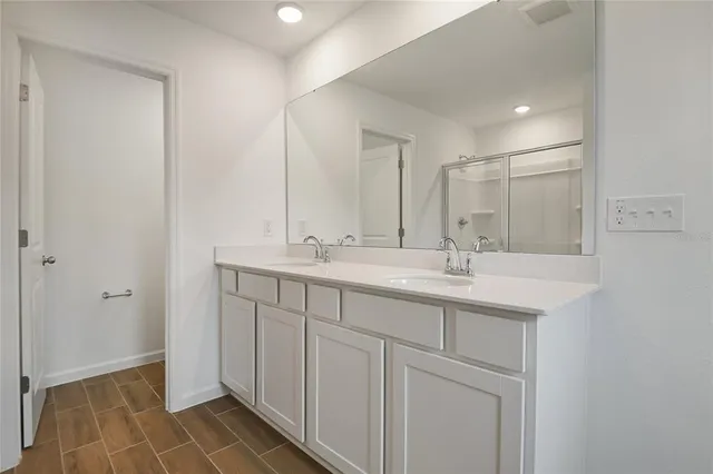 a bathroom with a double vanity sink and a mirror