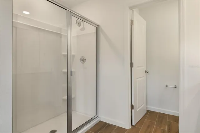a bathroom with a shower and a glass door