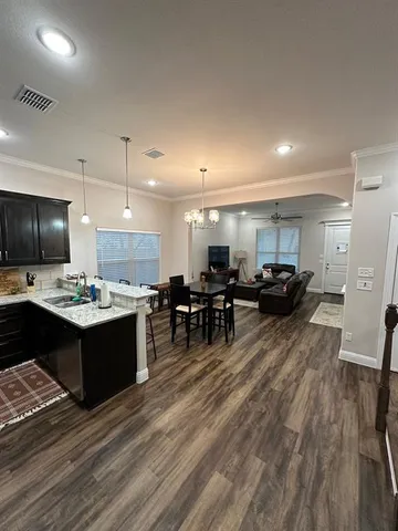 an empty room with a chandelier fan and windows