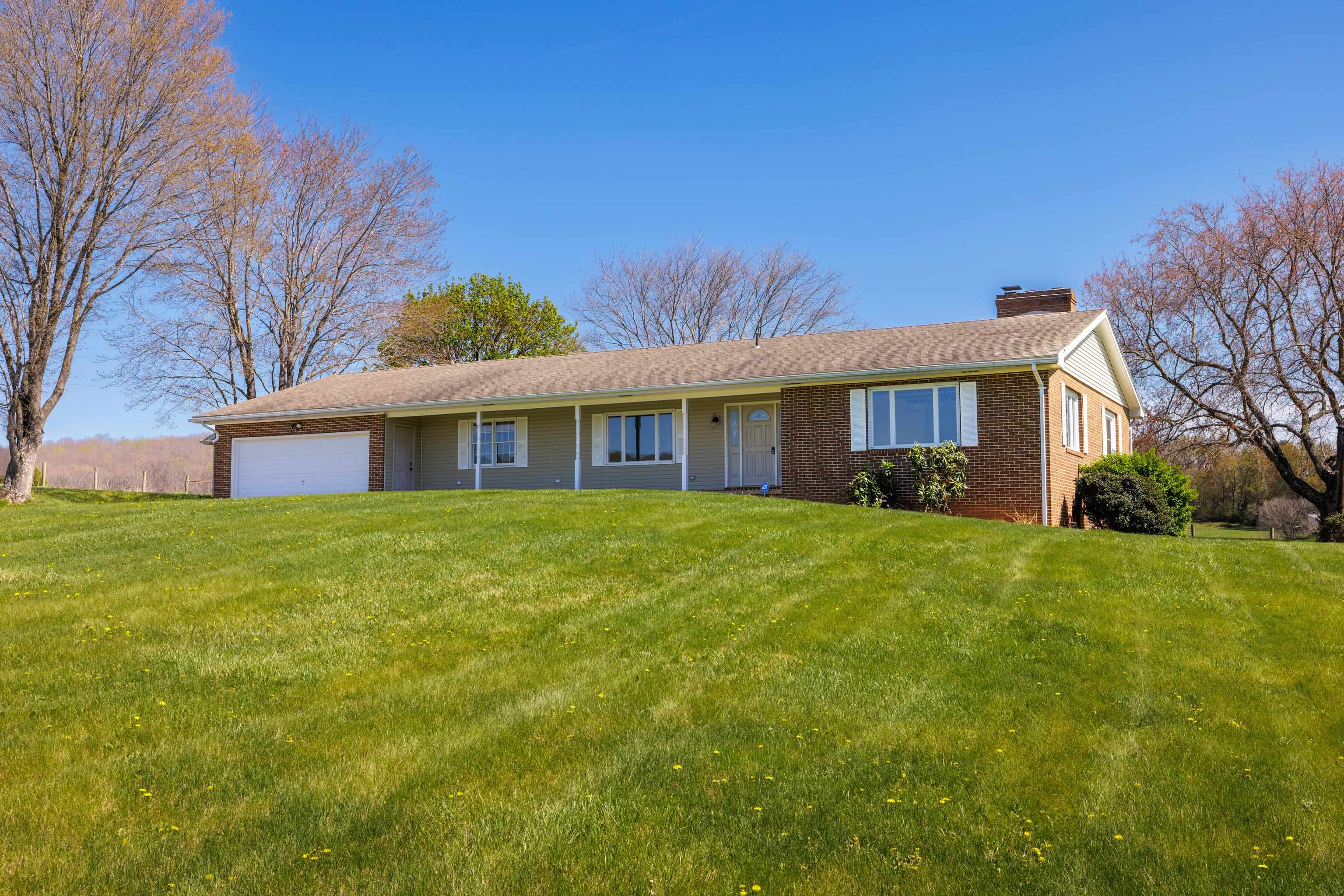 a front view of house with yard and green space