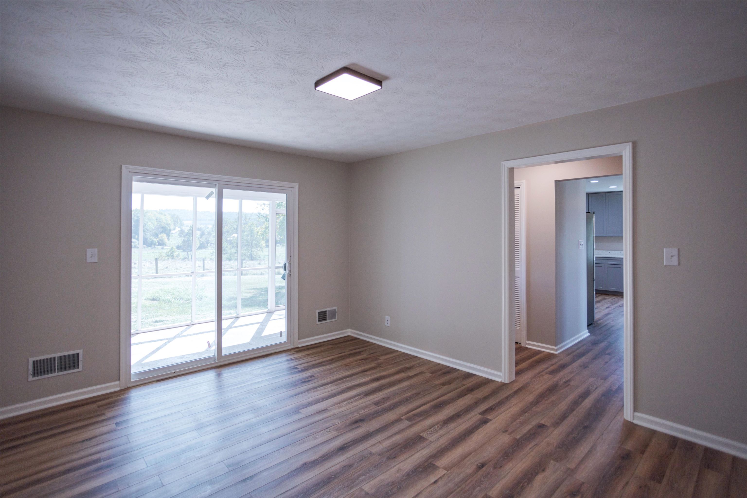 2834 Brownsburg Turnpike Raphine, VA 24472 - Photo 14 of 38 a view of an empty room with wooden floor and a window