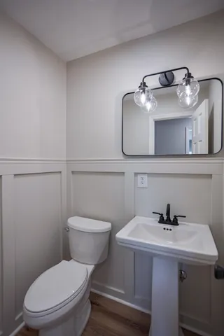 a bathroom with a sink a toilet and mirror