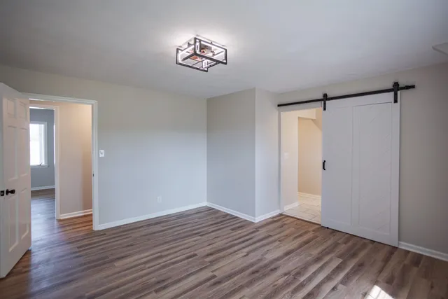 a view of an empty room with wooden floor
