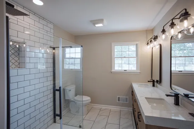 a bathroom with a sink a toilet and shower