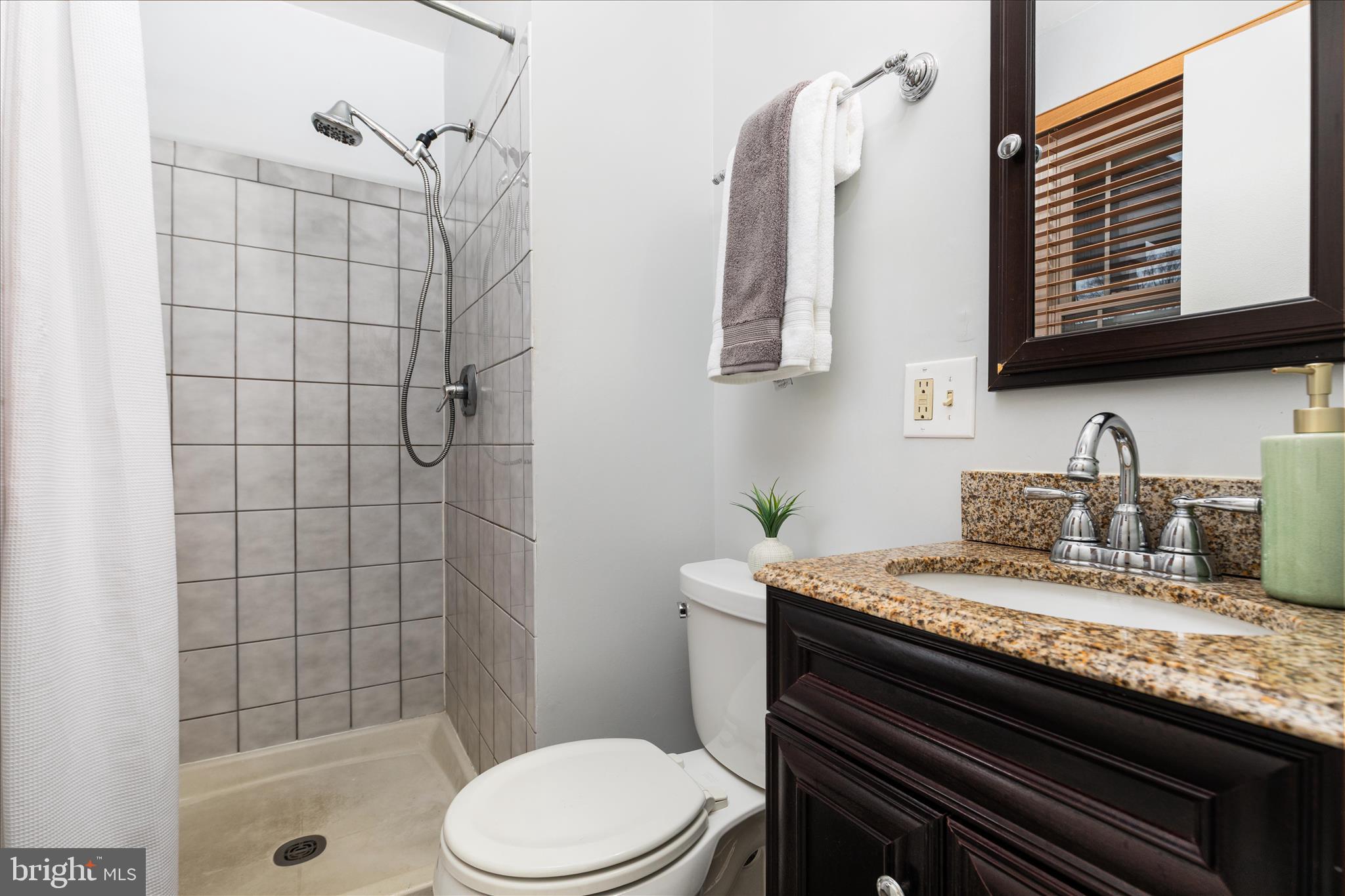 7398 Roxbury Avenue Manassas, VA 20109 - Photo 19 of 75 a bathroom with a granite countertop sink toilet and shower