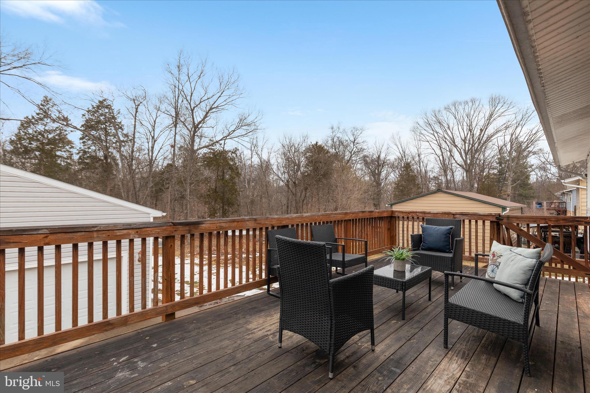 7398 Roxbury Avenue Manassas, VA 20109 - Photo 37 of 75 a view of a roof deck with table and chairs under an umbrella with wooden floor and fence