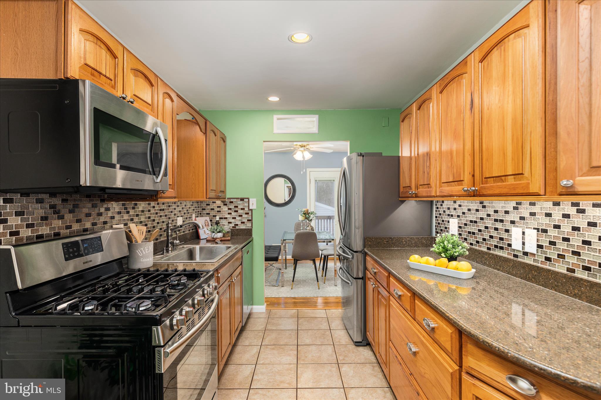 7398 Roxbury Avenue Manassas, VA 20109 - Photo 9 of 75 a kitchen with stainless steel appliances a stove a sink cabinets and a kitchen island