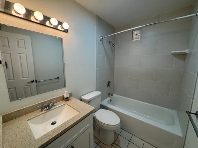 a bathroom with a sink mirror vanity and toilet