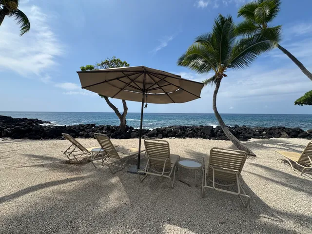 a view of a patio with table and chairs under an umbrella