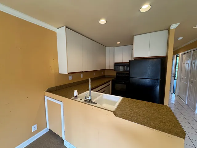 a kitchen with stainless steel appliances granite countertop a refrigerator a sink and a stove