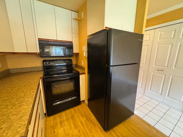 a kitchen with a refrigerator and a stove top oven