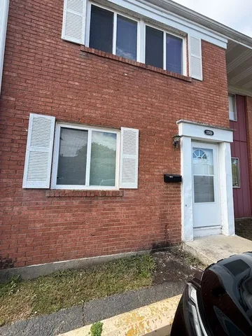 a brick house that has a small yard