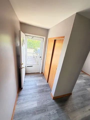 a view of a hallway with wooden floor and stairs