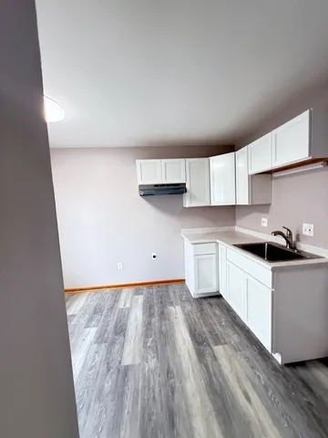 a kitchen with granite countertop white cabinets and white appliances