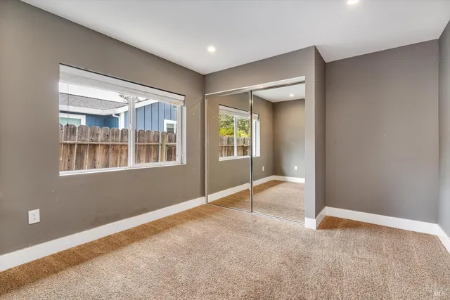 a view of a hallway with wooden floor and glass door