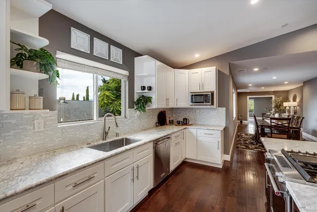 a kitchen with stainless steel appliances kitchen island granite countertop a sink and cabinets