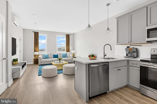 a view of kitchen with stainless steel appliances granite countertop a sink dishwasher stove and refrigerator with wooden floor