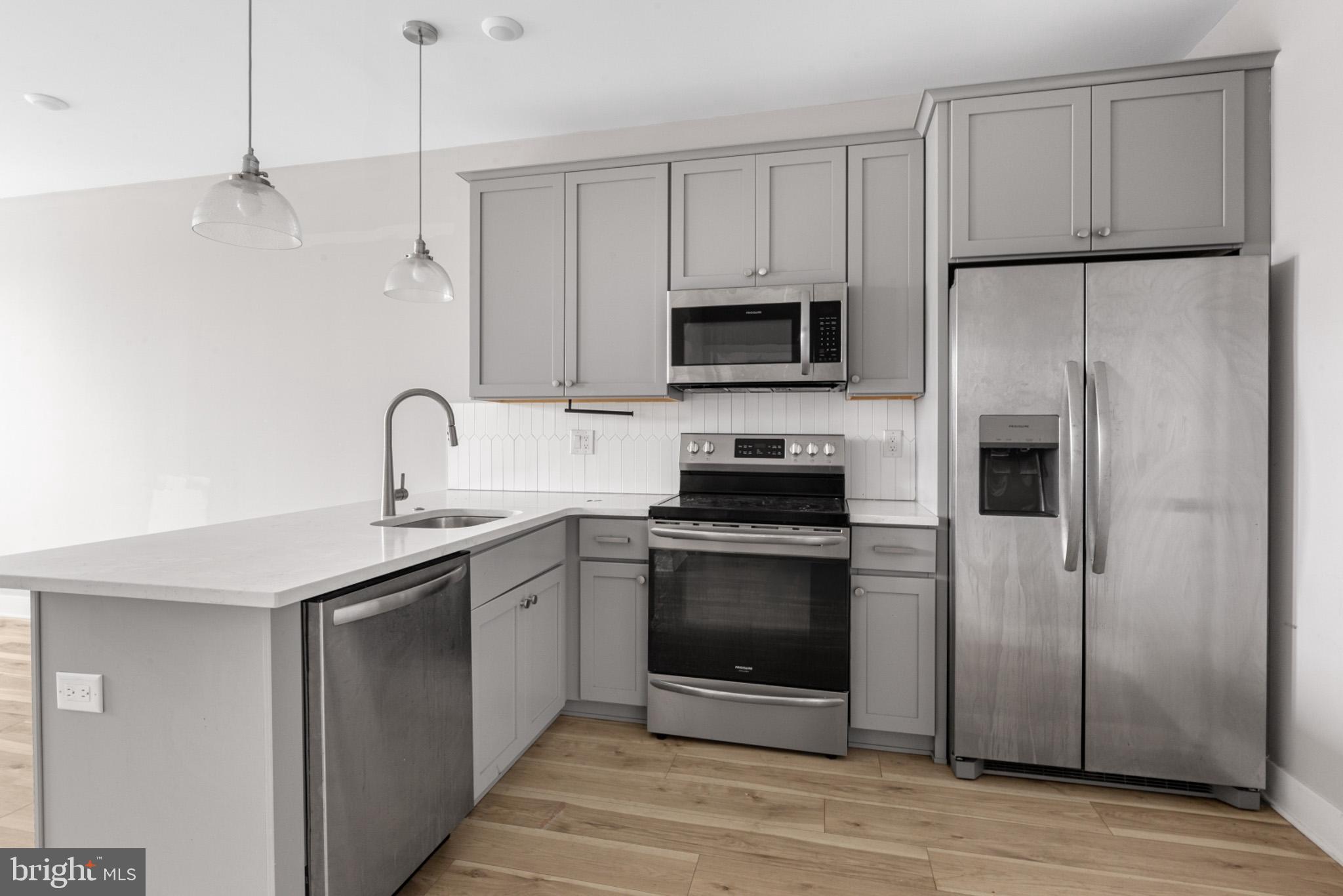 5230 Walnut Street, Unit 4R Philadelphia, PA 19139 - Photo 3 of 19 a kitchen with stainless steel appliances a refrigerator sink and microwave