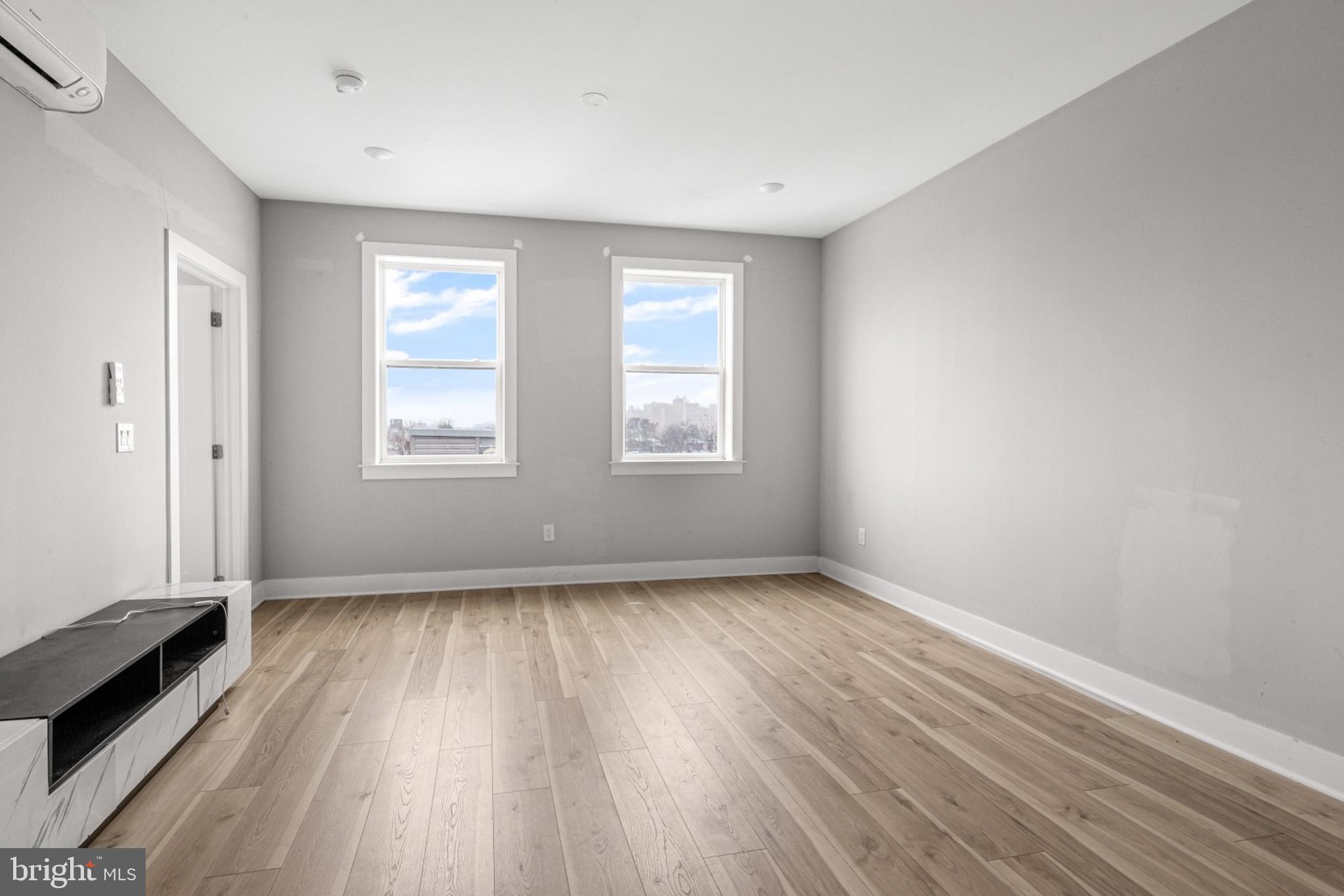 5230 Walnut Street, Unit 4R Philadelphia, PA 19139 - Photo 5 of 19 an empty room with wooden floor and windows