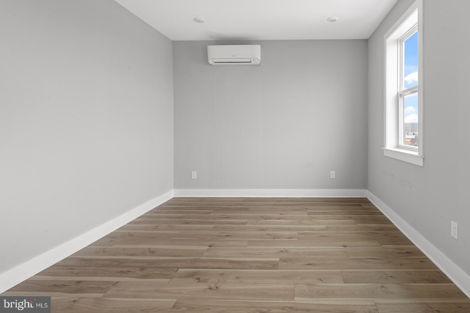 5230 Walnut Street, Unit 4R Philadelphia, PA 19139 - Photo 8 of 19 a view of an empty room with wooden floor and a window