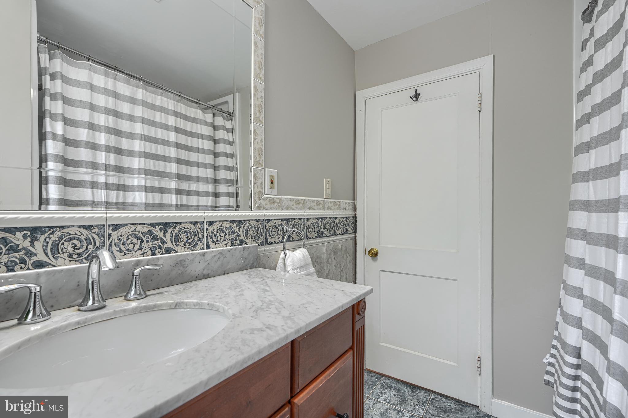 8132 Pleasant Plains Road Towson, MD 21286 - Photo 33 of 55 a bathroom with a granite countertop sink and a mirror