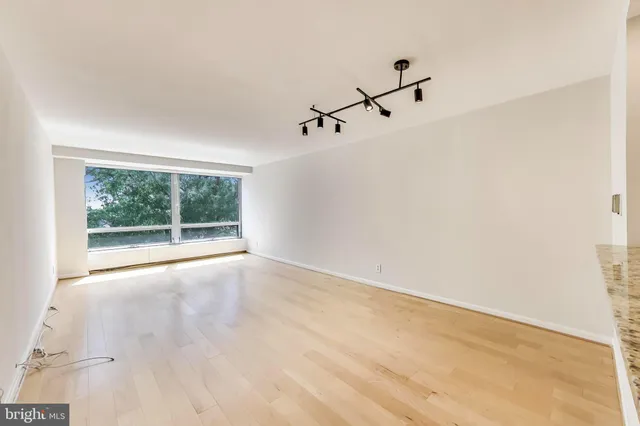 a view of a room with a white wall and a window