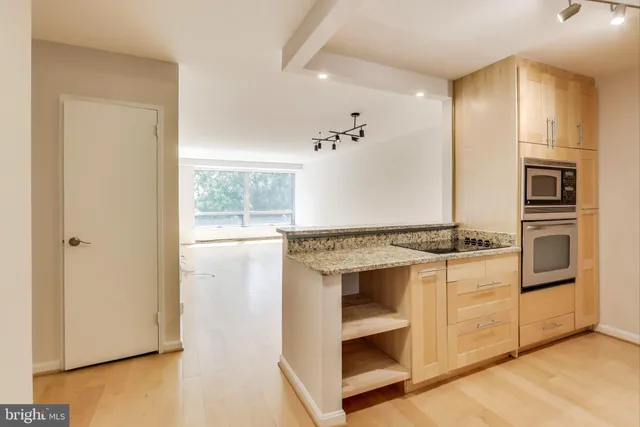 a kitchen with granite countertop a refrigerator and a sink