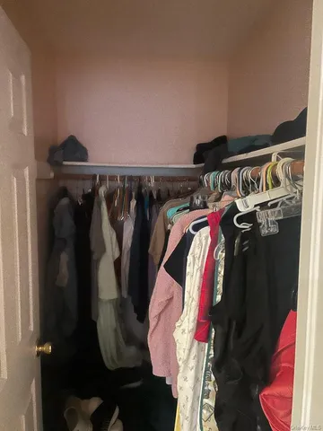 a view of walk in closet with clothes and shoes