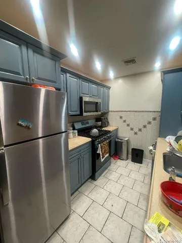 a kitchen with stainless steel appliances a refrigerator and a stove top oven