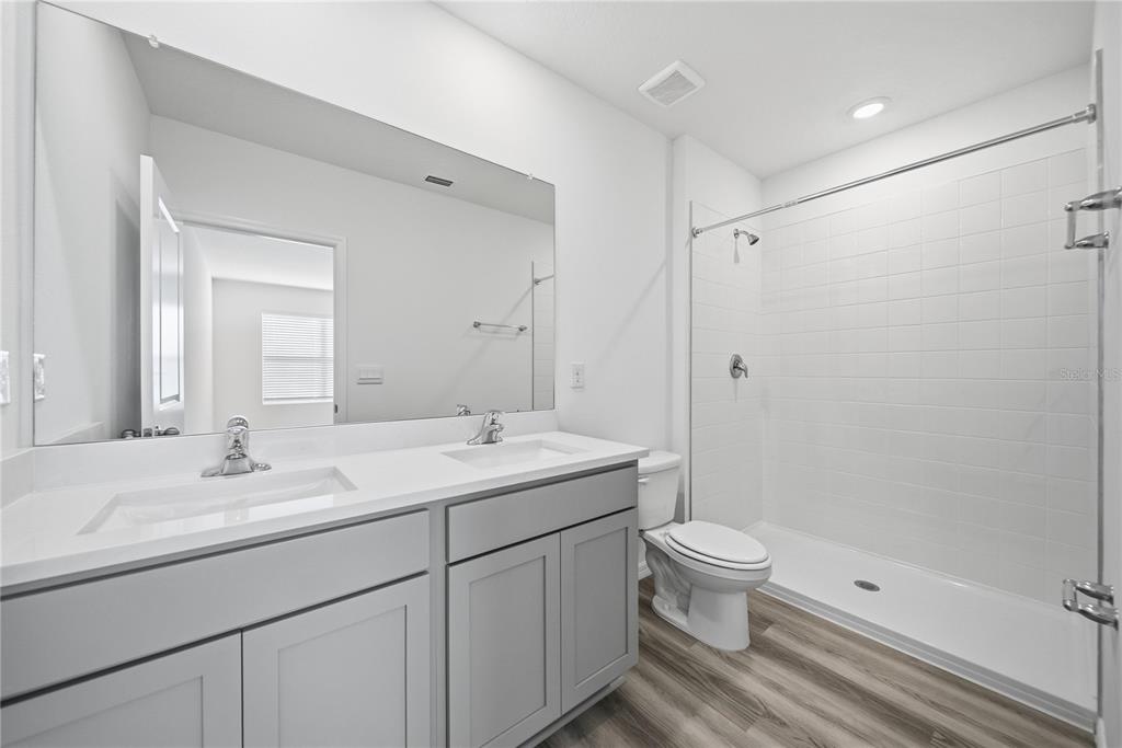 32497 Midsummer Night Lane Wesley Chapel, FL 33543 - Photo 17 of 30 a bathroom with a double vanity sink toilet and shower