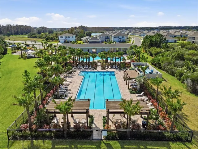 an aerial view of residential houses with outdoor space and pool