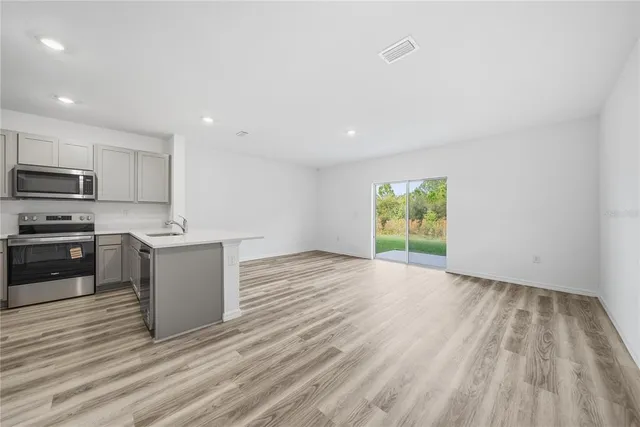 a kitchen with wooden floors and stainless steel appliances