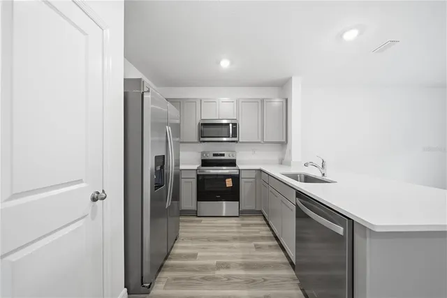 a kitchen with stainless steel appliances granite countertop a refrigerator and a sink