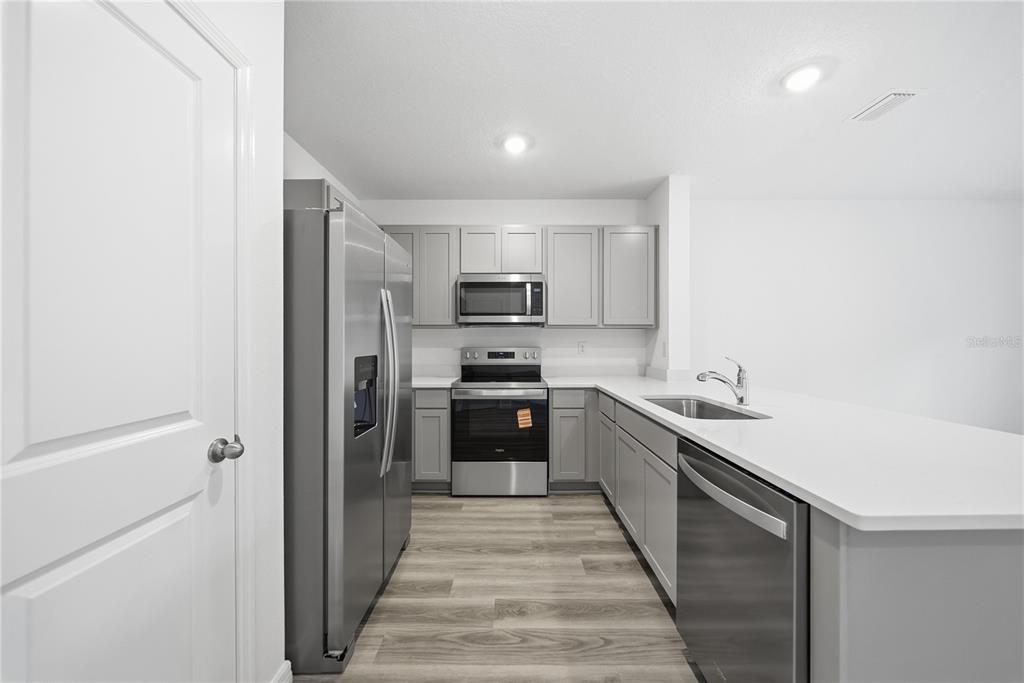32497 Midsummer Night Lane Wesley Chapel, FL 33543 - Photo 6 of 30 a kitchen with stainless steel appliances granite countertop a refrigerator and a sink