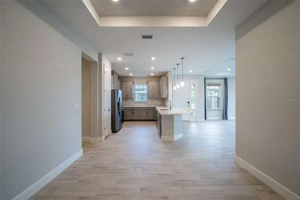 an empty room with wooden floor and a ceiling fan