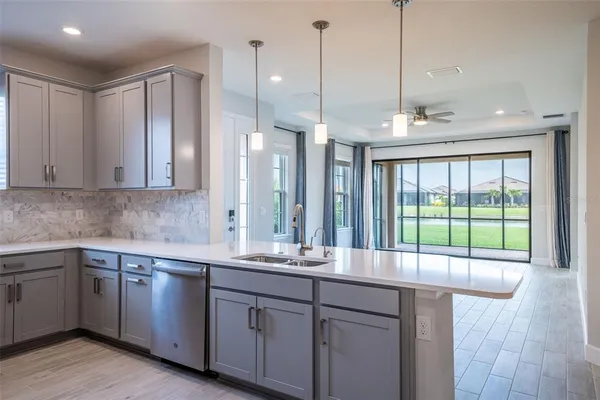 a view of an empty room with window and chandelier fan