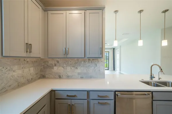 a view of a big room with a chandelier fan and a bathroom