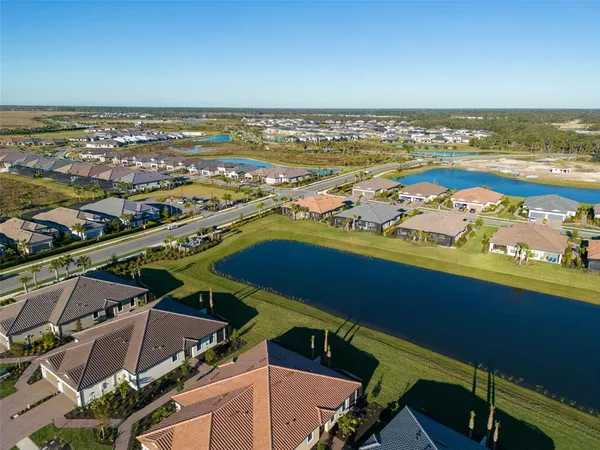 an aerial view of residential houses with outdoor space and ocean view