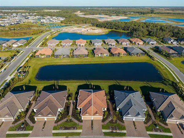 an aerial view of residential houses with outdoor space and ocean view