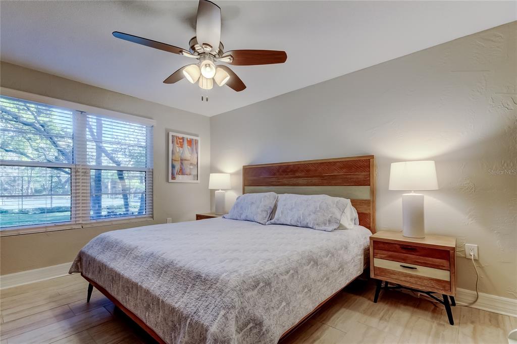 1407 Lennox Road East, Unit 1407 Palm Harbor, FL 34683 - Photo 24 of 48 a bedroom with a large bed and a chandelier